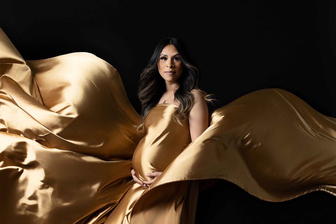 baby in belly wrapped in flowing gold fabric