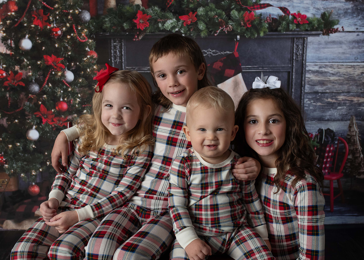 Group of four children in their matching Christmas outfits