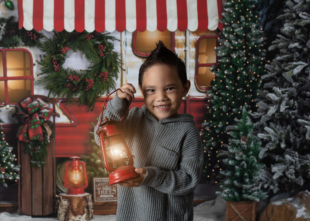 A little boy holding a lantern in an outdoor winter scene